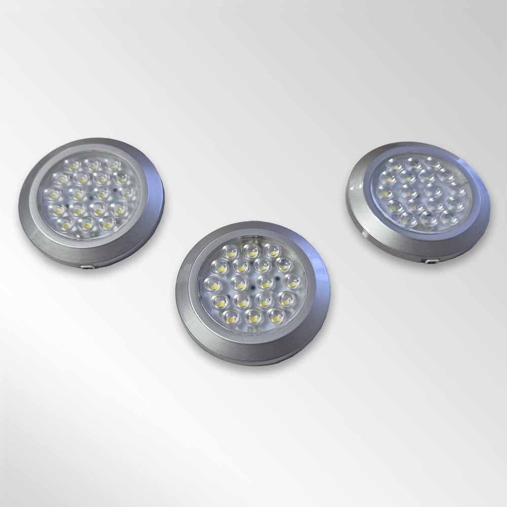 Three circular LED kitchen cabinet lights with silver rims on a white background