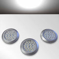 Three circular white LED kitchen cabinet lights with silver rims on a white background