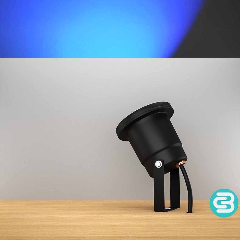 Black outdoor light fixture on a wooden surface with a blue LED light on a gray background.