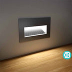 Modern wall-mounted light fixture on a neutral wall with a wooden floor.