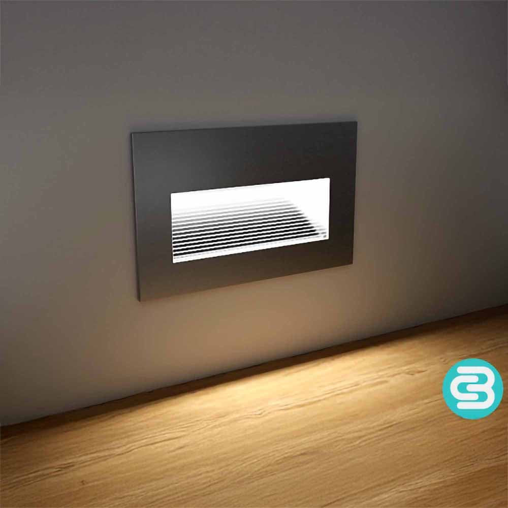 Modern wall-mounted light fixture on a neutral wall with a wooden floor.