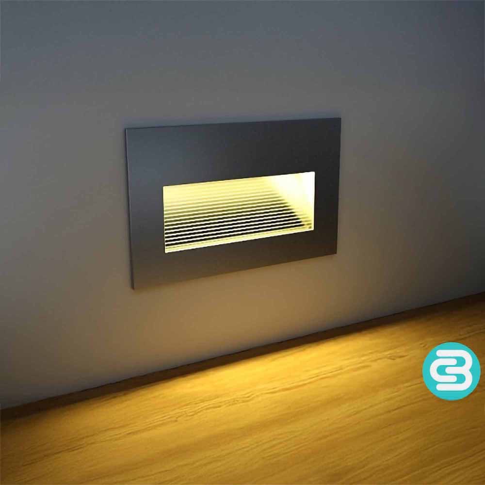 Modern wall-mounted light fixture emitting a warm white glow on a gray wall.